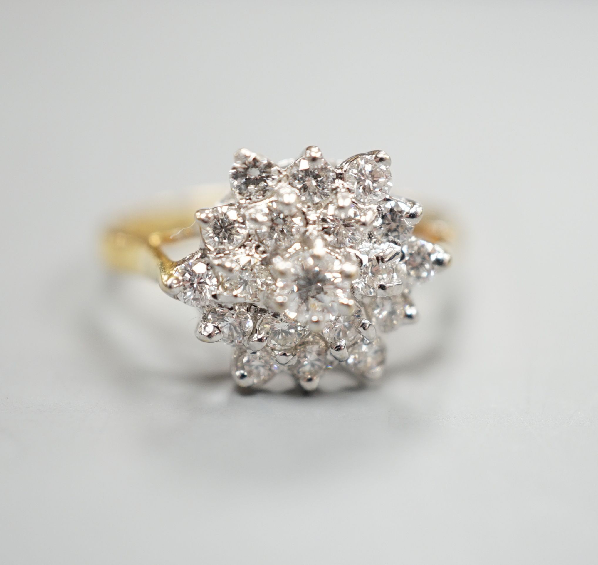 A modern 750 yellow metal and diamond set hexagonal cluster ring, size O, gross weight 3.4 grams.